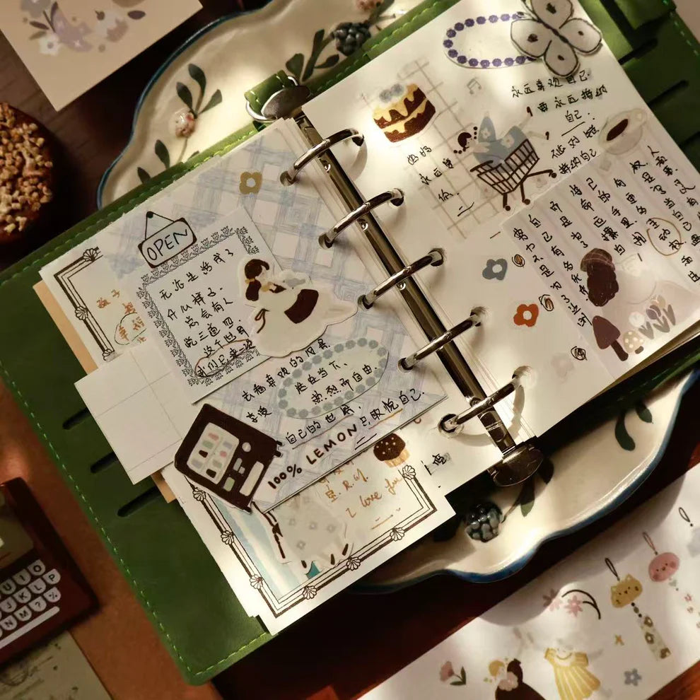 Second notebook spread decorated with Macaron Afternoon PET Tape designs on a wooden desk