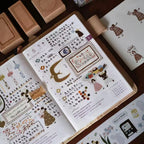 Open book with illustrated pages and text on a wooden surface