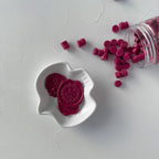 Pink cookies and cookie pieces on a white surface