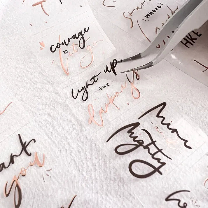 Sheet of temporary tattoos with motivational phrases and designs on a white background.