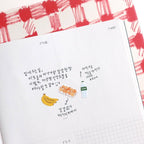 Notebook page with drawings of bananas, a bottle, and text on a red and white checkered background