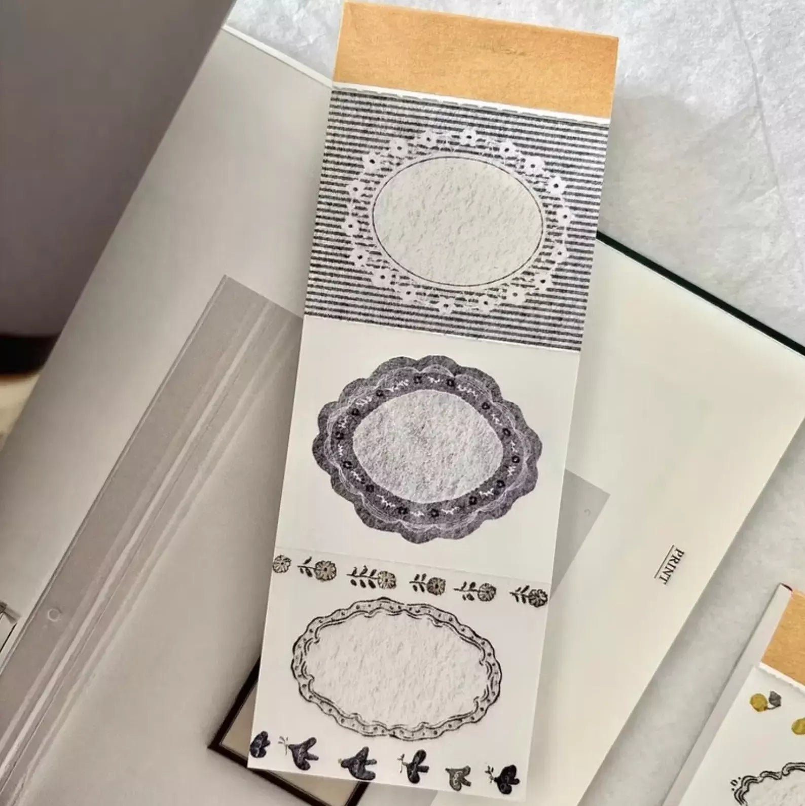 Blue Memo Pad by Pion with delicate lace-like perforated sheet patterns on a textured surface