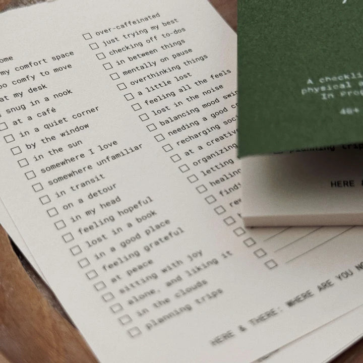 Checklist on a piece of paper with a green notebook in the background
