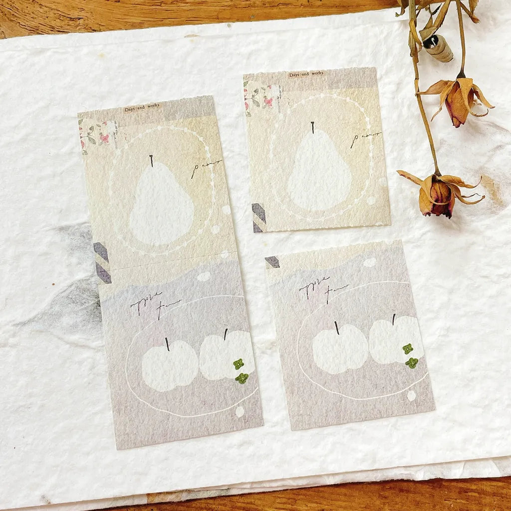 Set of four fabric tea towels with pear designs on a wooden surface.