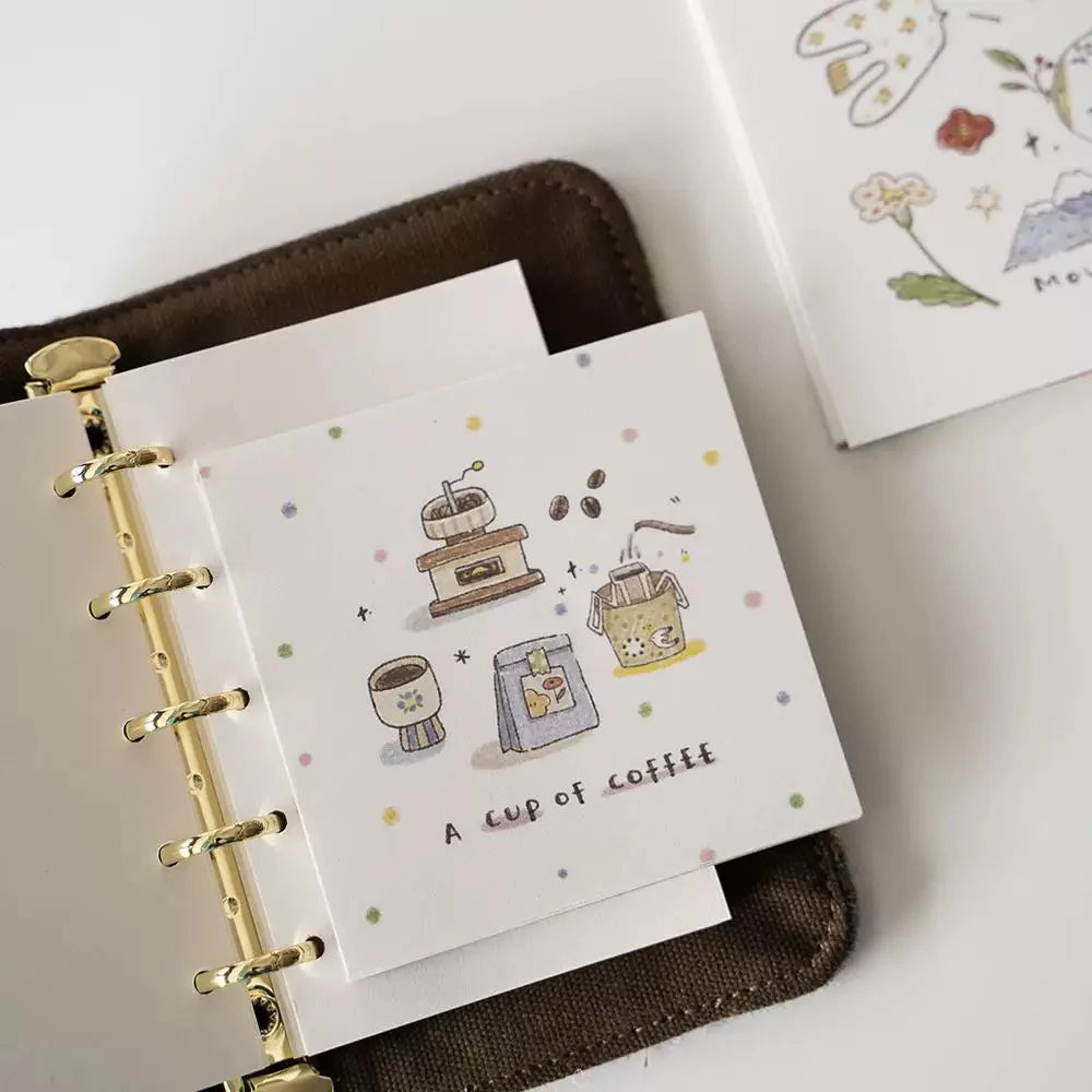 Notebook with coffee-themed illustrations and text on a white surface