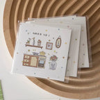 Card with kitchen illustration and 'Wake Up!' text on a wooden surface