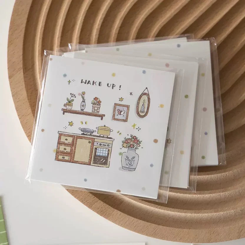 Card with kitchen illustration and 'Wake Up!' text on a wooden surface