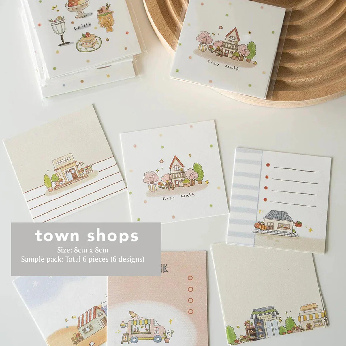 Set of small cards with town shop illustrations on a white surface.