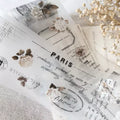Sheet of paper with 'Paris' text and floral designs on a textured surface.
