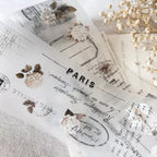 Sheet of paper with 'Paris' text and floral designs on a textured surface.
