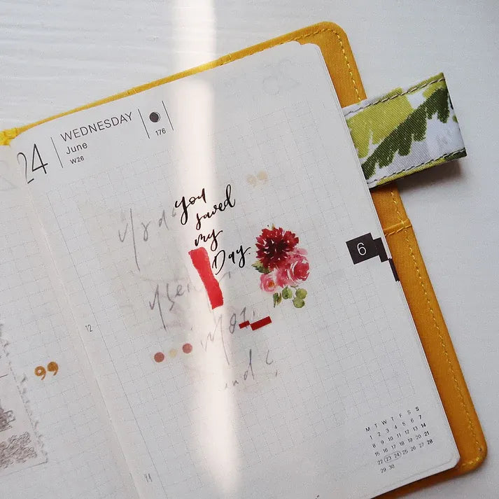 Notebook styled with a Messy Messy Washi Tape floral design and text on a clean white background