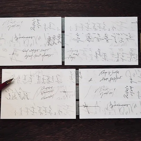 Four white cards decorated with Messy Messy Washi Tape script on a dark wooden surface, top view
