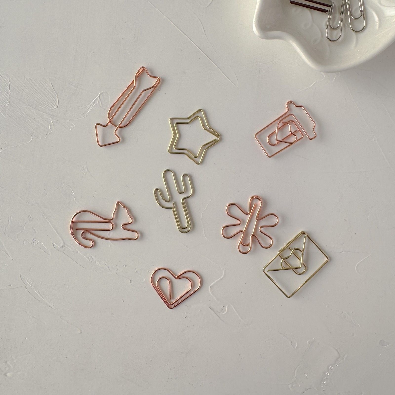 Set of various shaped paper clips on a light gray surface