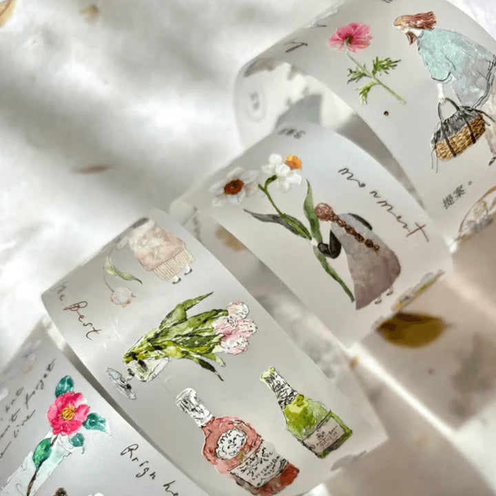 Rolls of Mini Girl 01 Matte PET Tape with floral and perfume-bottle designs on a textured surface