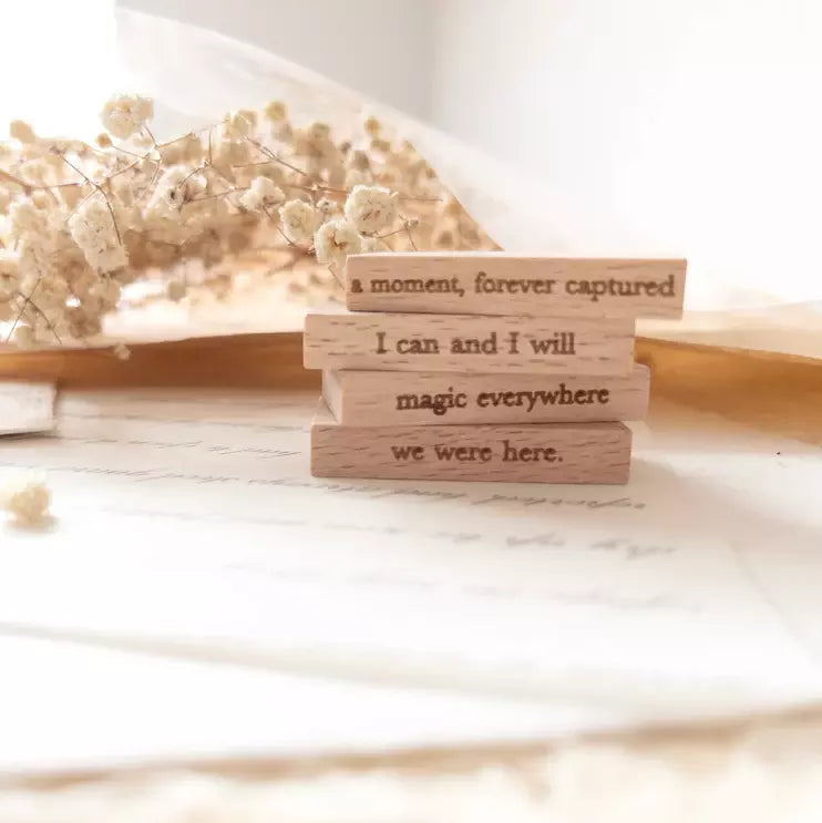 Mini Quote Rubber Stamps Vol. 2 stack of wooden blocks with engraved quotes on a soft backdrop