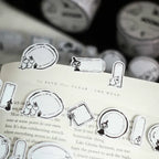 Black and white illustrations on a book with washi tape in the background