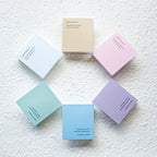 Set of pastel-colored notebooks on a textured white surface