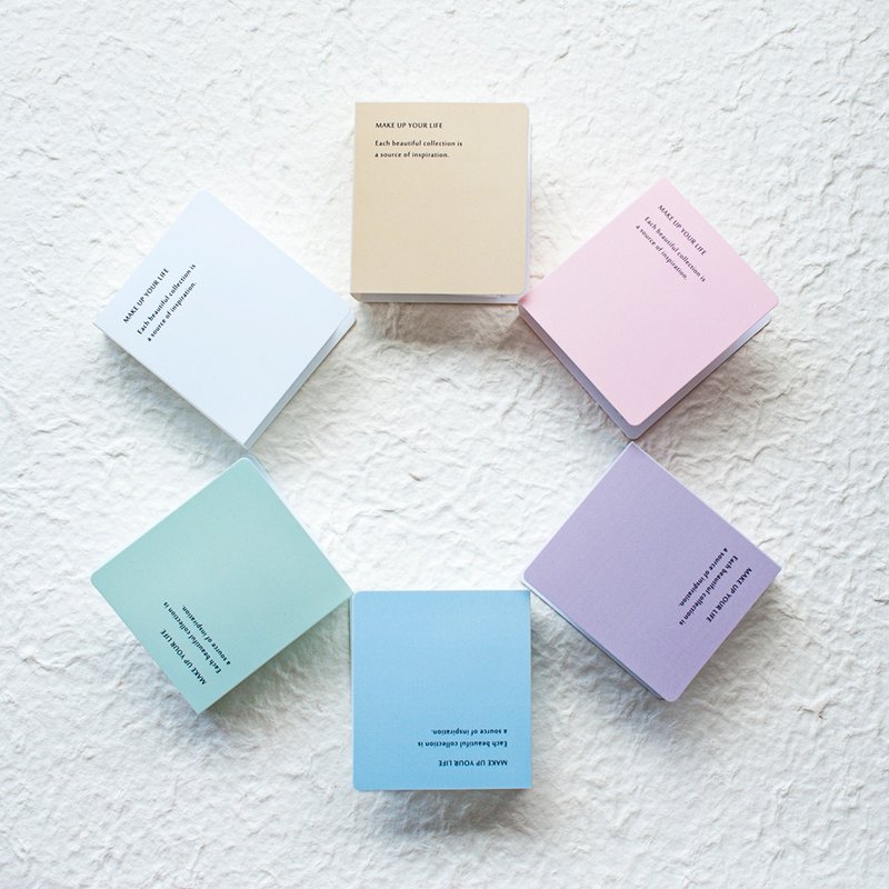 Set of pastel-colored MU Ephemera Storage Books stacked on a textured white surface