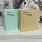 Two books with motivational text on a white surface with a patterned background