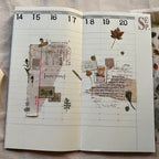 Open planner with decorative pages and text, featuring a leaf and 'September' text.