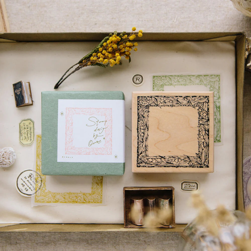 Collection of rubber stamps and stationery items in a box with decorative elements.