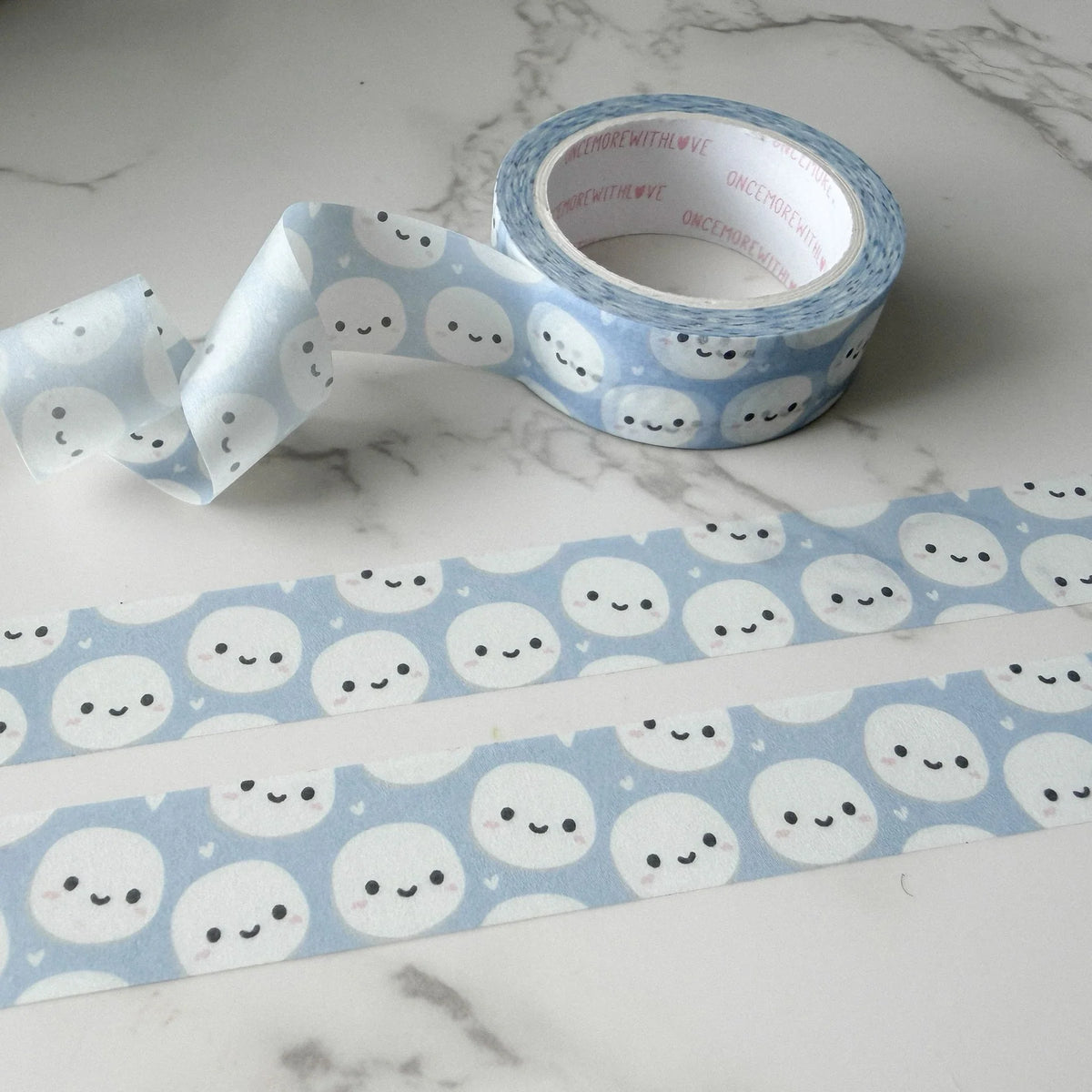 Roll of Munchkin Heads Blue Washi Tape with ghost pattern on a marble surface