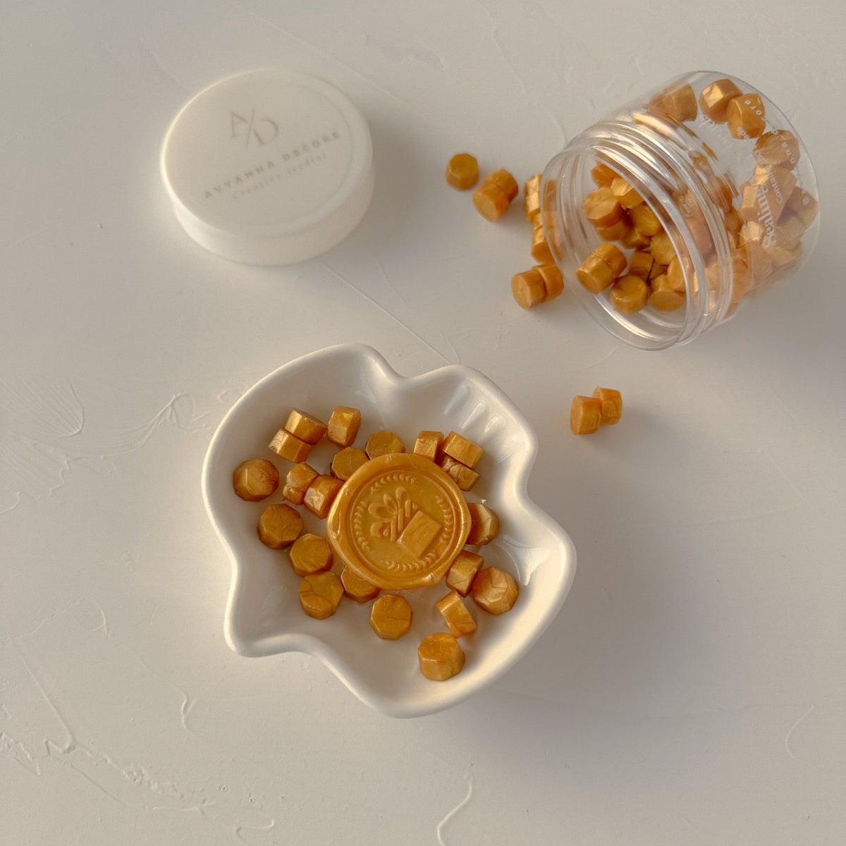 Mustard Orange Wax Beads in a white dish and clear container, warm vintage tones on a light grey backdrop