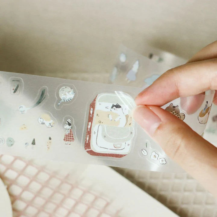 Hand holding a clear sheet of My Home Cat PET Tape die-cut pieces on a light background