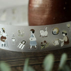 Roll of decorative tape with illustrations on a wooden surface