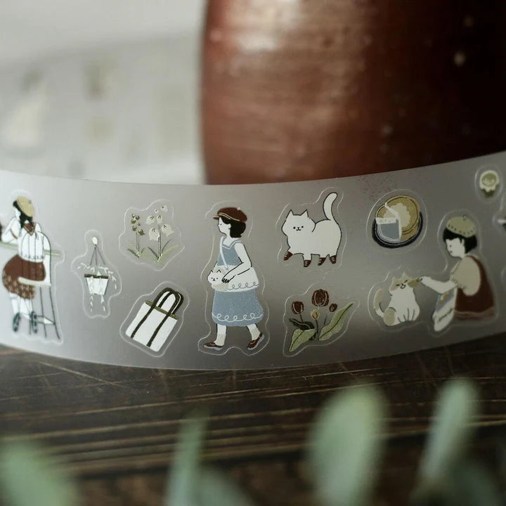 Roll of Neko Cafe PET Tape by Teayou with cat cafe illustrations resting on a wooden surface