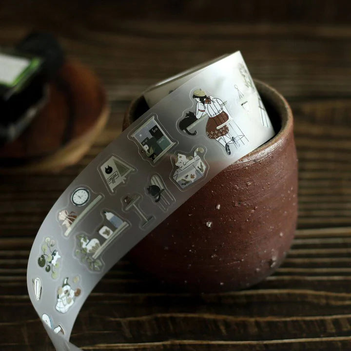 Ceramic cup wrapped with a Neko Cafe PET Tape band of cats and text on a wooden surface