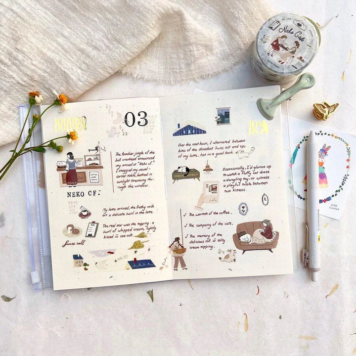 Open book decorated with Neko Cafe PET Tape illustrations beside a jar and fresh flowers