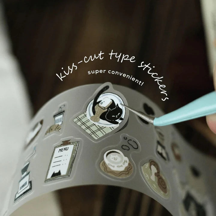 Kiss-cut roll of Neko Cafe PET Tape with a craft tool and text detail on a dark background