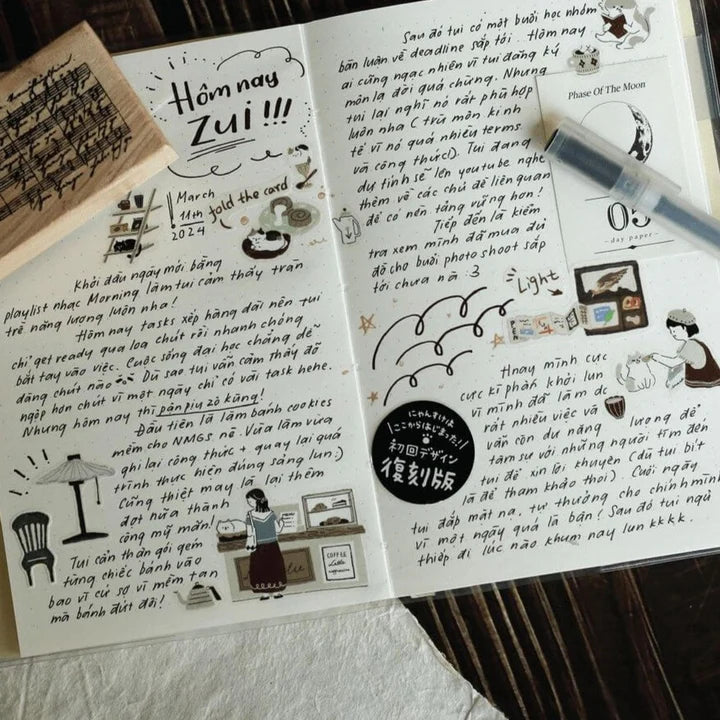 Open notebook with handwritten text decorated with Neko Cafe PET Tape cat illustrations