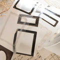 Clear photo frames with black borders on a textured surface