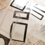 Clear photo frames with black borders on a textured surface