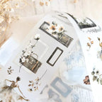 Decorative paper with floral and suitcase designs on a white background