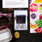 OURS Studio 2027 Journal flat-lay with a bicycle card, fruit print and gingham bow