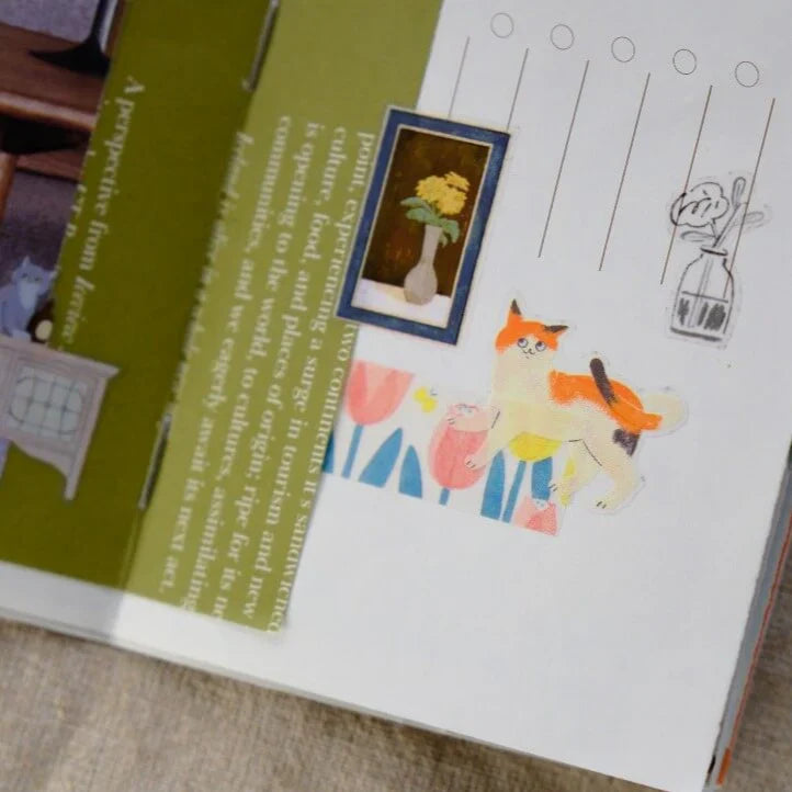 Open book decorated with Life With Cats PET Tape animal and flower illustrations on white