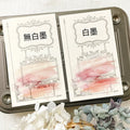Two cards with decorative designs and Chinese text on a metal tray with flowers.