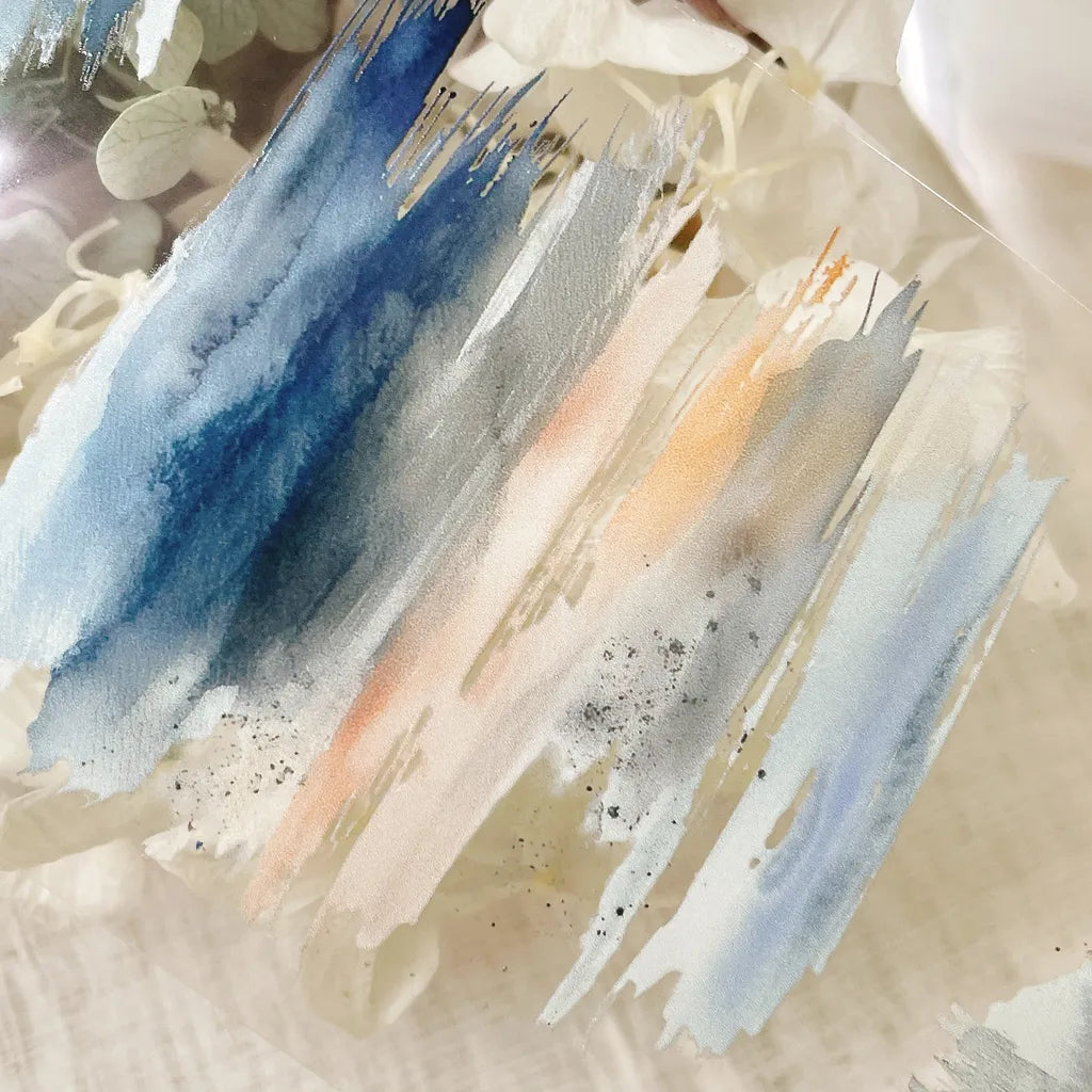 Abstract art with blue, orange, and gray brush strokes on a textured beige background