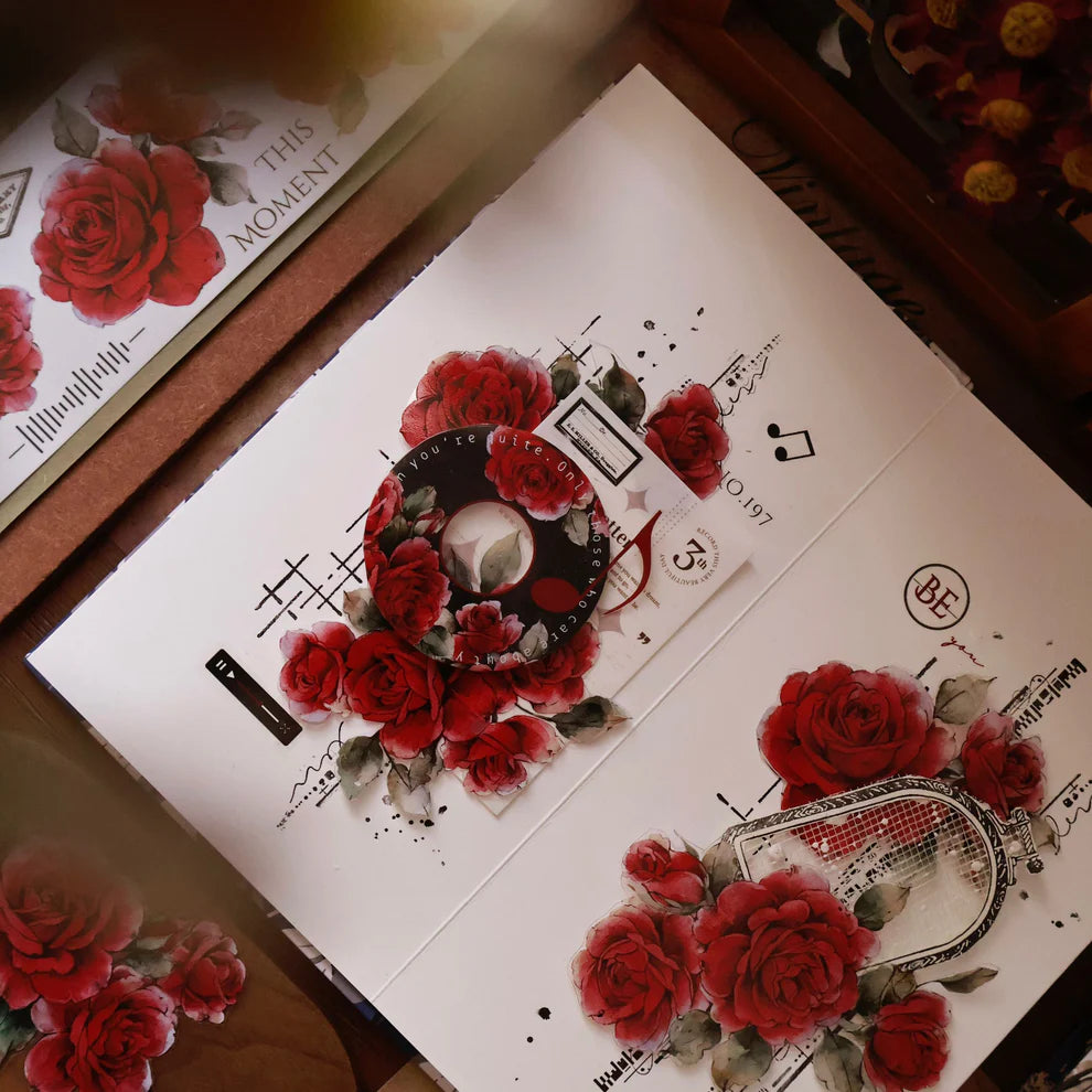 Product packaging with red roses and decorative elements on a wooden surface