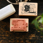 Two wooden stamps with illustrations on a dark surface