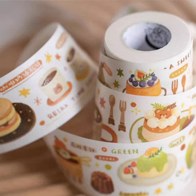 Rolls of decorative tape with food-themed designs on a light background
