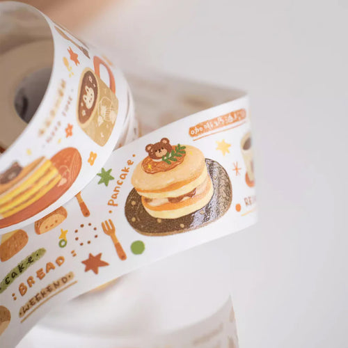Roll of decorative tape with food-themed illustrations on a white background