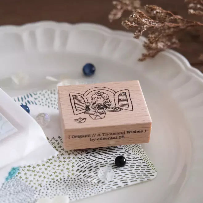 A Thousand Wishes Paper Boats origami stamp with text displayed on a decorative plate