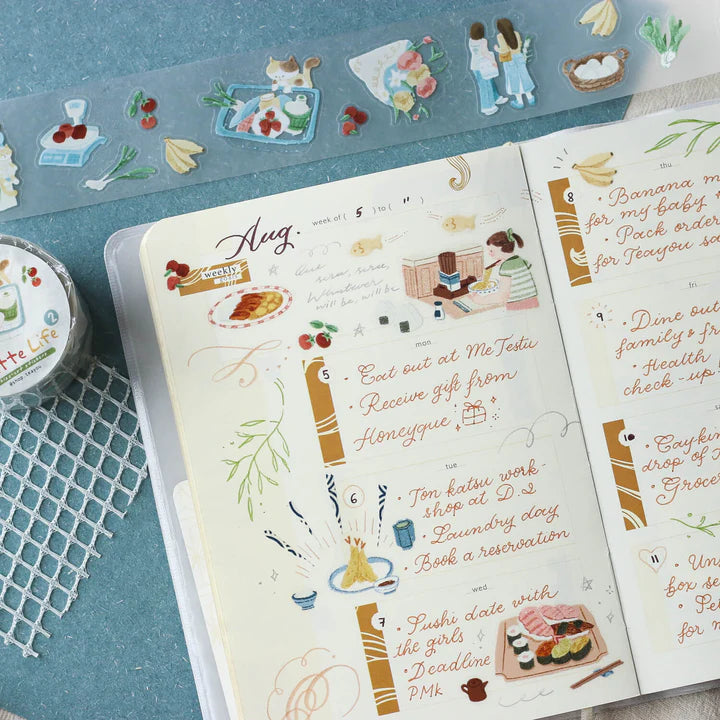Planner decorated with Palette Life 2 PET Tape illustrated stickers on a blue surface