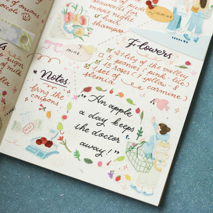 Open book styled with Palette Life 2 PET Tape deco text and illustrations on a blue surface