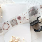 Sheet of decorative stickers with floral designs on a white surface with a spool of twine.