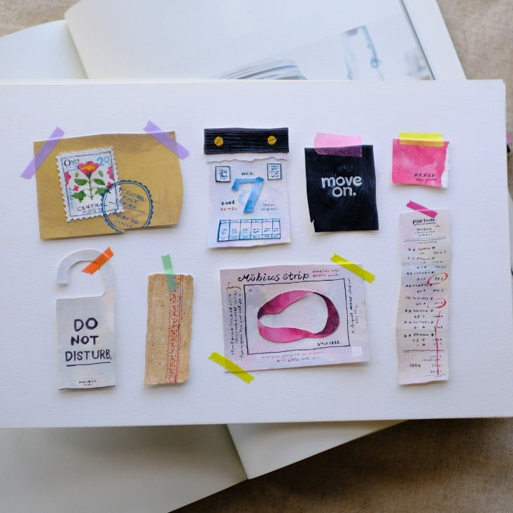 Paper Lover PET Tape deco pieces on white paper with a pen and stationery in the background